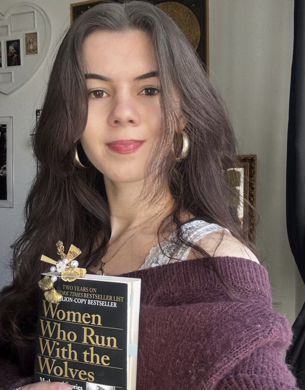 Selfie of Melissa holding "Women who run with the wolves" by Clarissa Pinkola Estés.